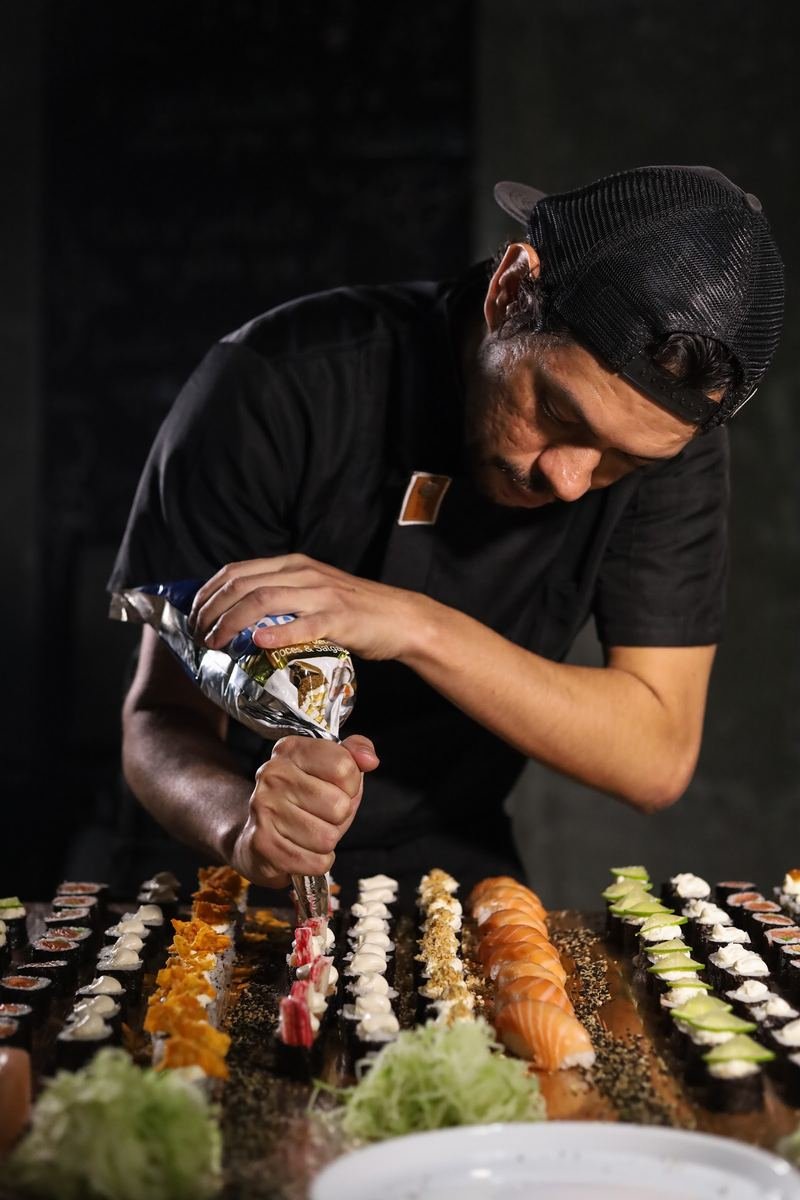 Sushiman finalizando uma peça na hora, à vista dos convidados